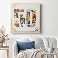 a white couch sitting next to a table with a vase on it and pictures hanging above the couch