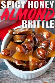 a bowl filled with honey almond brittle on top of a wooden table