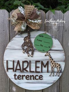 a wooden sign that says harlem terrace with two giraffes hanging from it