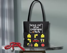 a black tote bag sitting on top of a table next to scissors and a pair of red handled shears