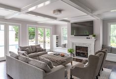 a living room filled with furniture and a flat screen tv mounted on the wall above a fireplace