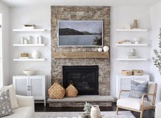 a living room filled with furniture and a fire place in front of a stone fireplace