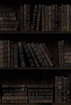 an old bookshelf filled with lots of dark colored bookcases and wooden shelves