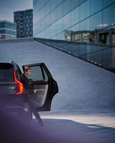 a woman sitting in the driver's seat of a car with her door open