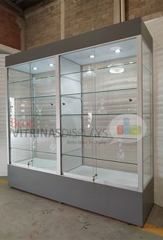 an empty display case with glass doors in the middle of a warehouse flooring area