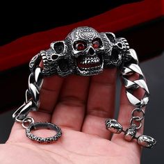 This chain bracelet features three skulls with the center skull having evil red eyes Details: Metals Type: Stainless Steel Material: Metal Item Type: Bracelets Clasp Type: Toggle-clasps Chain Type: Link Chain Check Out More pendant HERE Skull Bracelet Men, Skeleton Bracelet, Man Bracelet, Skull Fashion, Skull Bracelet, Skull Head, Skull Jewelry, Vintage Gothic, Skull Ring