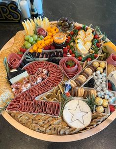 a platter filled with lots of different types of cheeses and meats on top of each other