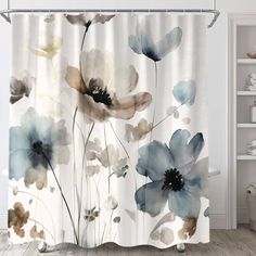 a shower curtain with blue and white flowers painted on it's side, hanging in a bathroom