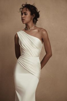 a woman in a white dress posing for the camera