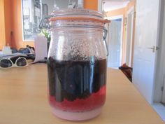 a jar filled with liquid sitting on top of a wooden table