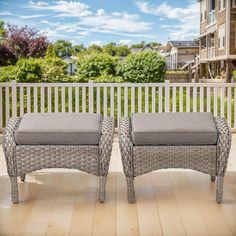 two wicker benches sitting on top of a hard wood floor next to a white fence