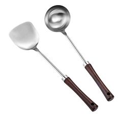 two metal spoons with wooden handles and one has a spatula in the middle