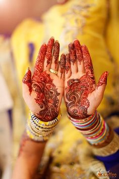 a woman's hands with henna tattoos on them