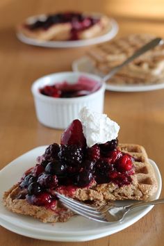 a waffle topped with berries and whipped cream