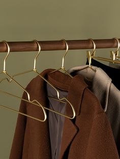 clothes hangers are hanging on a wooden rail