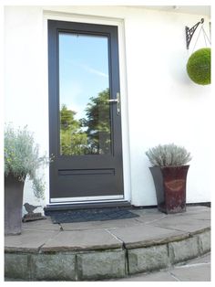 a black front door with two planters next to it