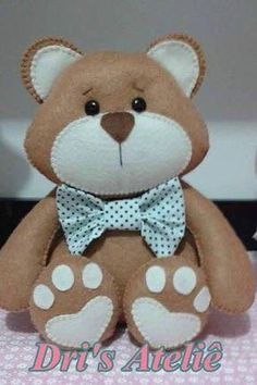 a brown teddy bear sitting on top of a pink and white tablecloth with polka dots