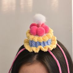 a woman wearing a crochet hat with a heart on top