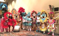 a group of people standing next to each other wearing colorful costumes and headdress