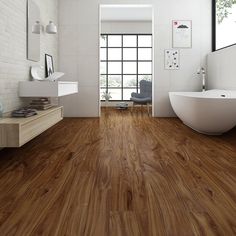 a bathroom with wood flooring and white bathtub next to a large window in the corner