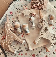 an assortment of wooden toys and decorations on top of a christmas themed table cloth,