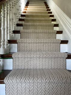 the stairs are lined with carpet and wooden handrails