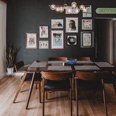 a dining room table with chairs and pictures on the wall