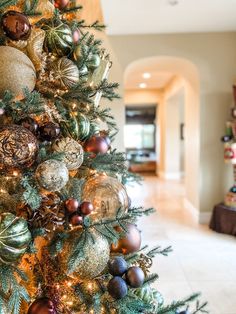 a decorated christmas tree in the middle of a living room with lots of ornaments on it