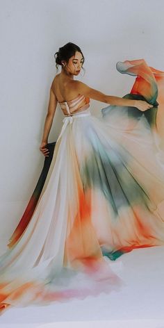 a woman in a colorful dress is posing for the camera