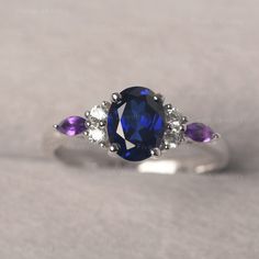 * The delicate ring displays sapphire as main stone. The cluster side stones make the ring similar to the blooming flower . For who wearing this special & delicate ring, will shine like a goddess. ◆ Production Description: Main stone Type: Lab Sapphire Main Stone Shape: Oval Cut Main Stone Size: 6*8mm (1.75ct) Side stone: CZ & Amethyst Metal: 925 Sterling silver - Other options available in the drop down menu ◆ Customization: √Free for Add Engraving √Other Metal Type Available √Other Gem Amethyst And Sapphire Ring, Oval Multi-stone Sapphire Diamond Ring, Oval Sapphire Multi-stone Diamond Ring, Sapphire Multi-stone Oval Diamond Ring, Oval Multi-stone Sapphire Cluster Ring, Purple Sapphire Oval Ring For Wedding, Purple Oval Sapphire Wedding Ring, Classic Sapphire Rings In Purple, Elegant Multi-stone Sapphire Birthstone Ring