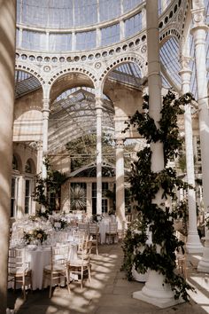 the inside of a building with tables and chairs set up for a formal dinner in it