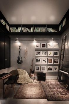 a room with bookshelves and various pictures on the wall, including a guitar