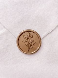 an envelope with a wax stamp on it and a flower in the center is shown