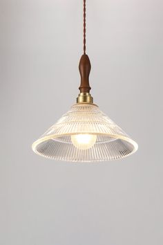 a light fixture hanging from a ceiling with a wooden handle and glass shades on it