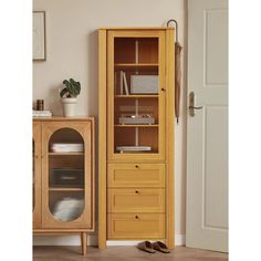 a tall wooden cabinet sitting next to a door