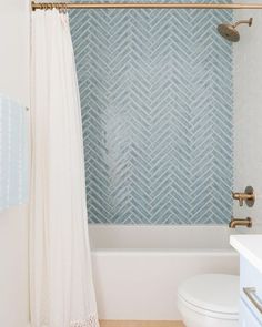 a white toilet sitting next to a bath tub under a shower curtain in a bathroom