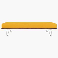 a yellow bench sitting on top of a wooden shelf next to a white wall with hairpin legs