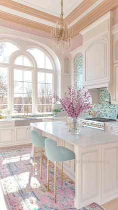 a large kitchen with an island in the middle and two blue chairs at the end