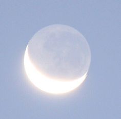 the moon is seen in front of a clear blue sky