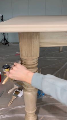 someone is painting the legs of a table