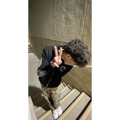 a man making the peace sign while standing on stairs