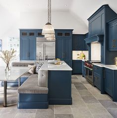 a large kitchen with blue cabinets and marble counter tops