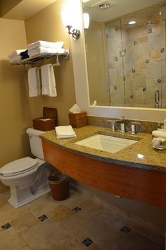 a bathroom with a sink, toilet and mirror