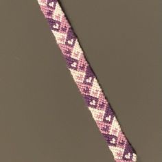 a purple and white beaded bracelet on a gray background