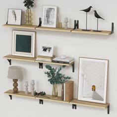 three wooden shelves with pictures and other items on them