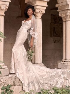 a woman in a wedding dress standing on some steps with her hand on her hip