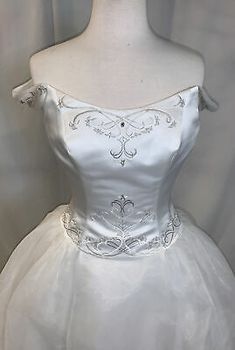 a white wedding dress on a mannequin headdress with silver beading