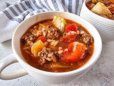 two white bowls filled with soup on top of a table