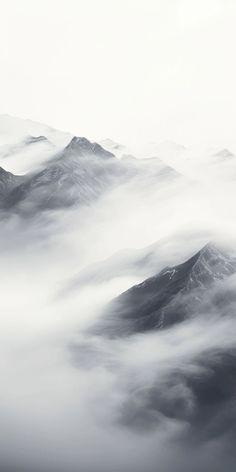 the mountains are covered with thick clouds in this black and white photo from an airplane