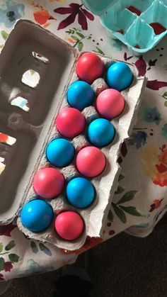 an egg carton filled with pink and blue eggs